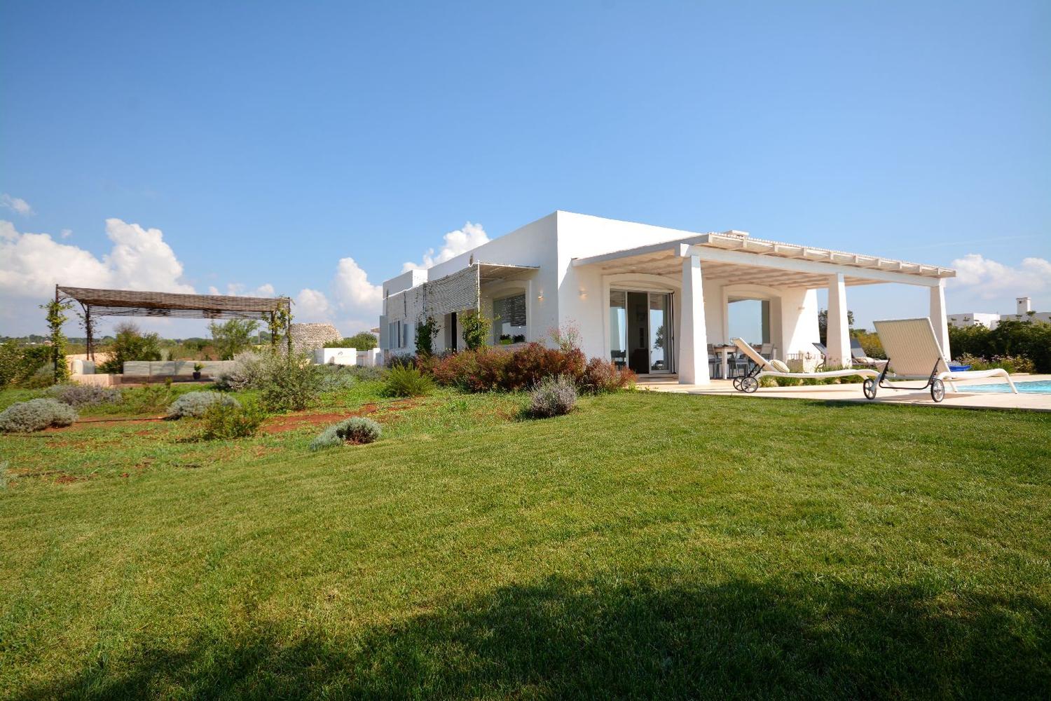 Die Villa, der Garten und die Pergola mit Sofas mit Meerblick
