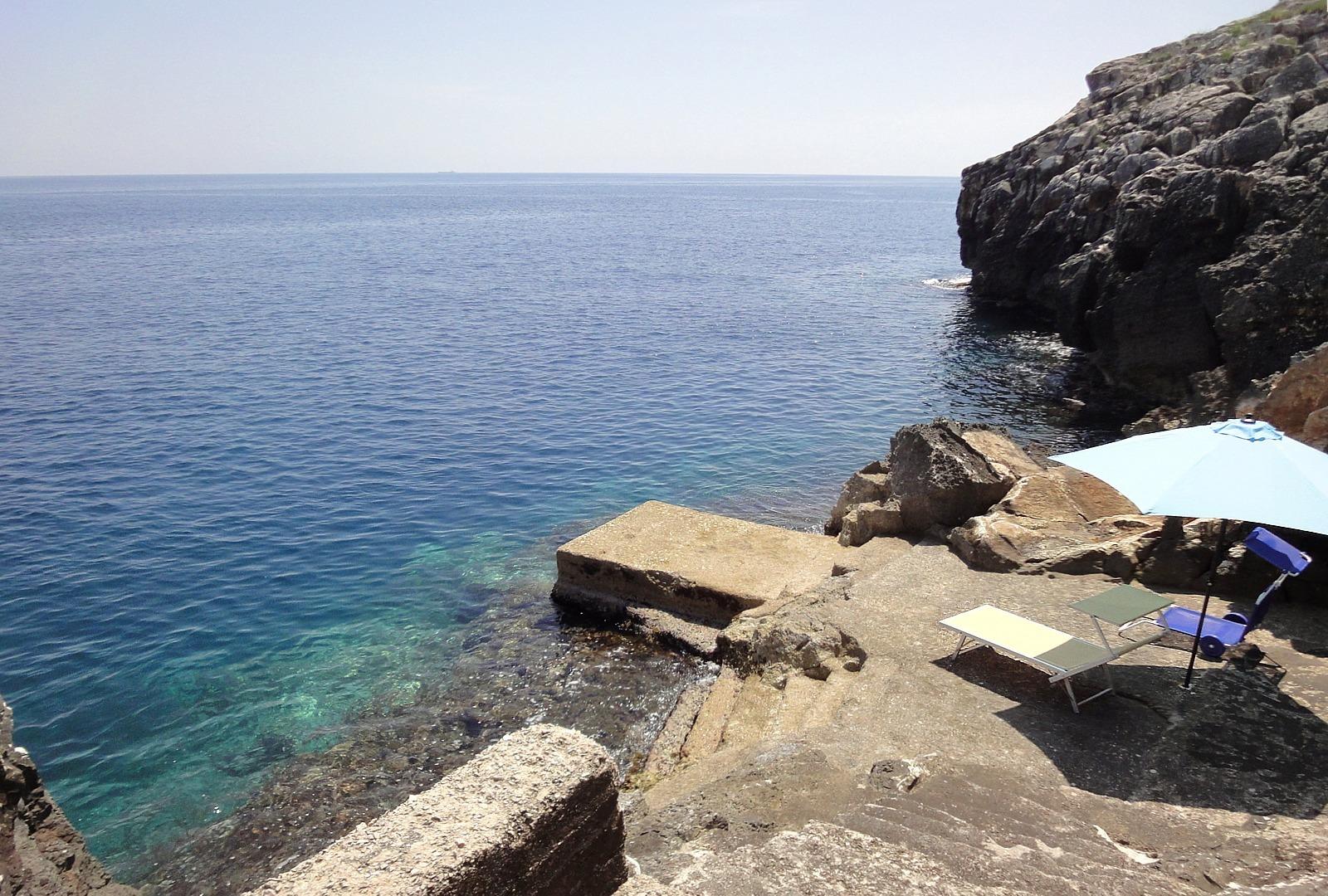 Mer Confortable crique rocheuse privée avec la plate-forme et les escaliers pour entrer dans l‘eau